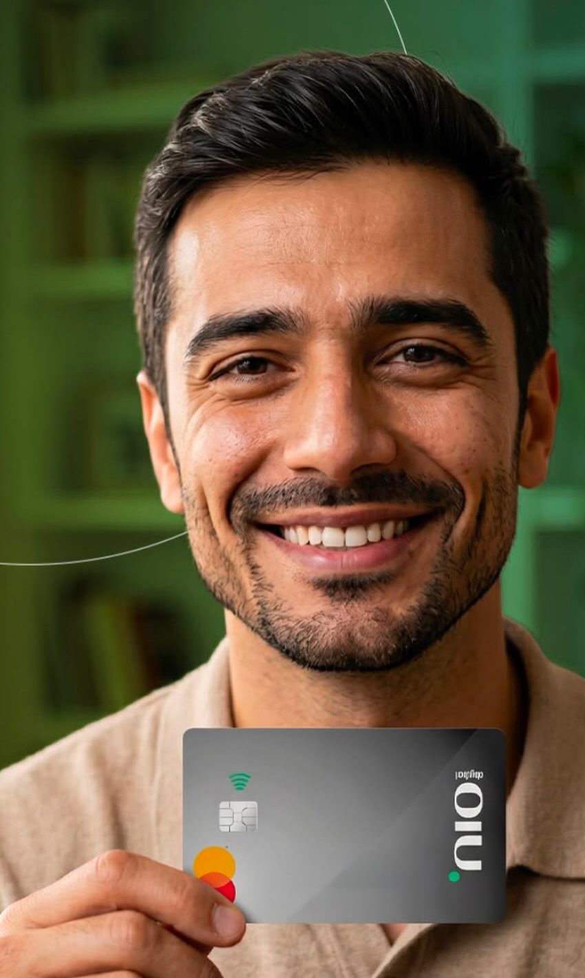 Cliente sorrindo segurando o cartão de crédito consignado NIO Digital Mastercard